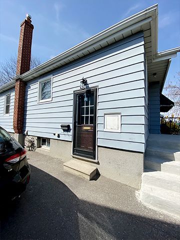 A blue house with a car parked in front of it.