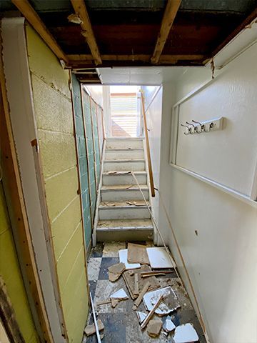 A hallway with stairs leading up to the second floor of a building.