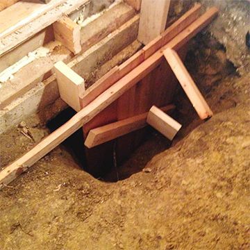A hole in the ground with wooden blocks in it