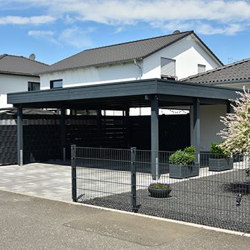 A white house with a black carport in front of it