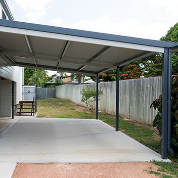 There is a carport in the backyard of a house.