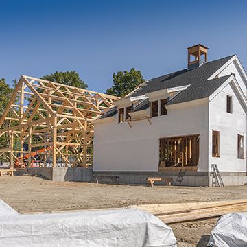 A white house is being built with a wooden frame.