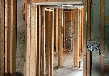 A room with wooden walls and a door in a house under construction.