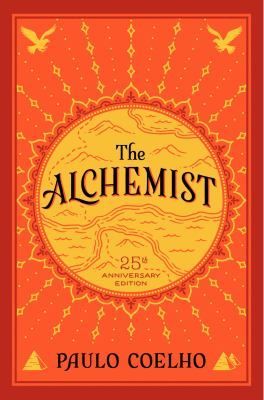 Book cover of The Alchemist by Paulo Coelho, orange-red with gold decorative border and 25th anniversary seal