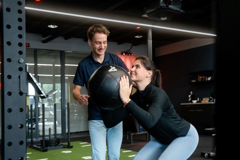 Fysiotherapeut van Revital Fysio | Werk | Fit geeft begeleiding bij deelnemer tijdens de groepsles