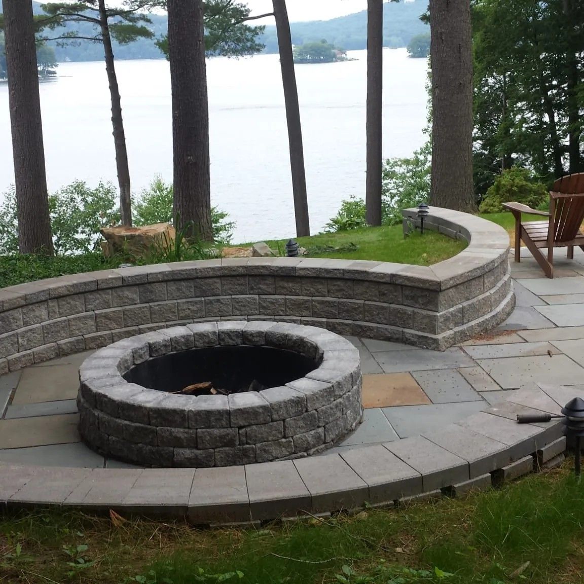 A fire pit with a view of a lake in the background