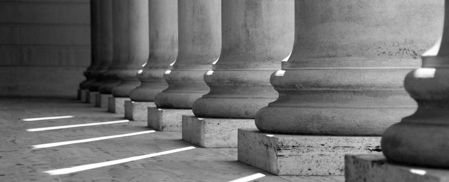 A black and white photo of a row of columns in a building.