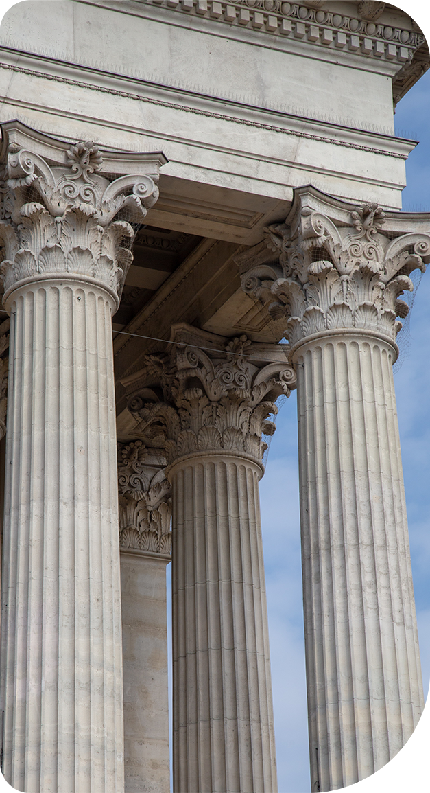 A building with columns and a blue sky in the background.