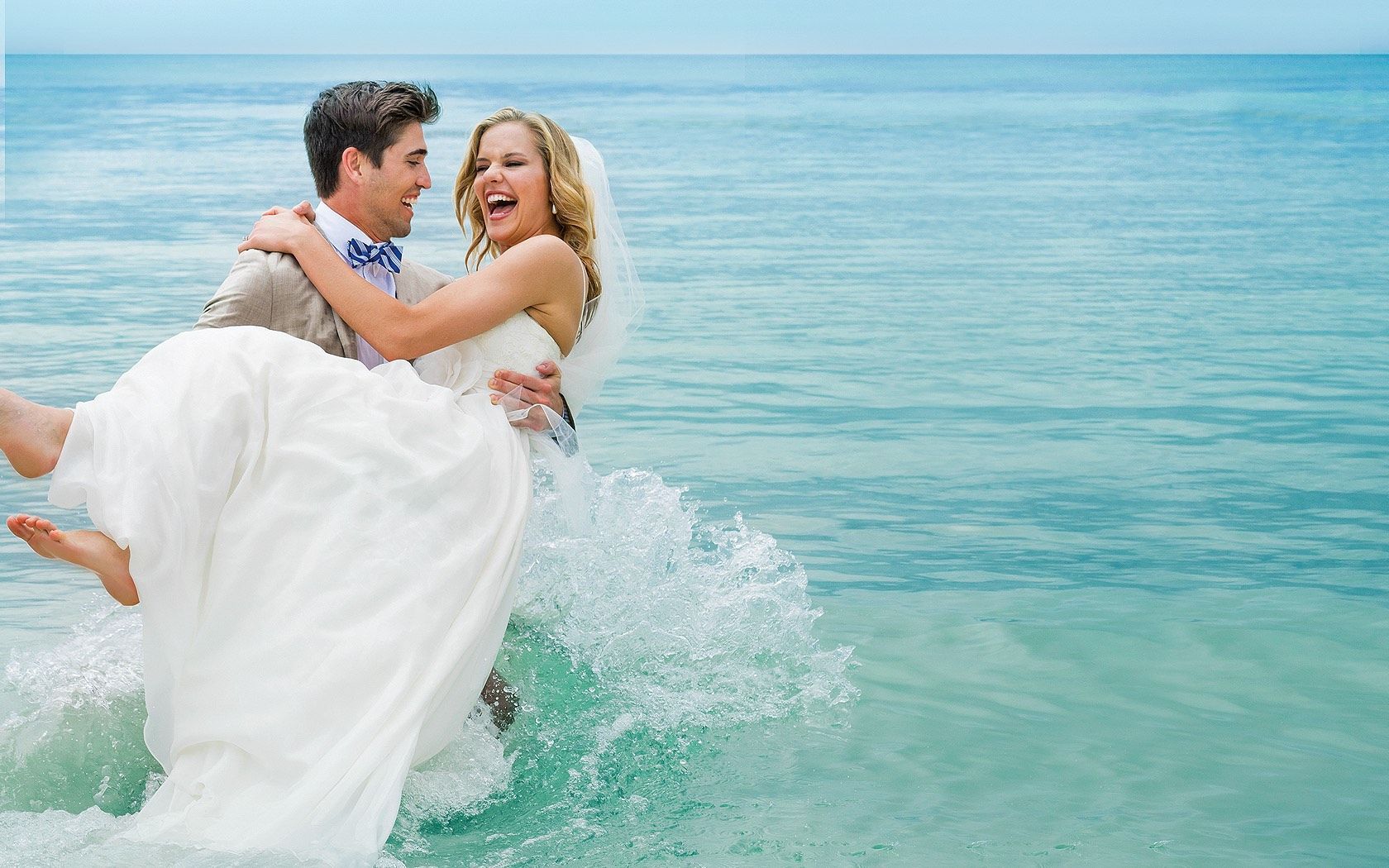 bride and groom wearing wedding dress and tuxedo in the water