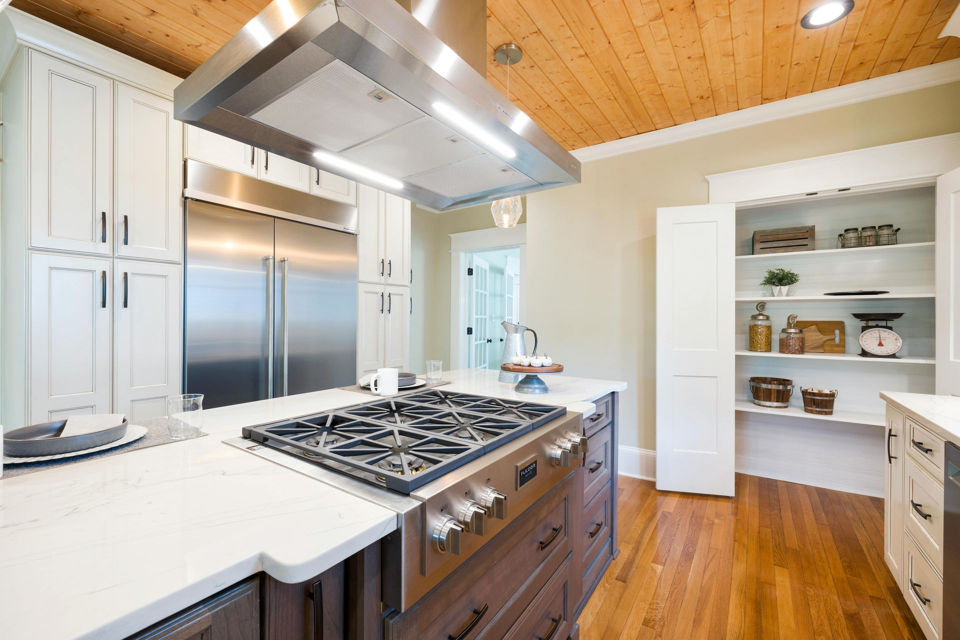 Modern kitchen with stainless steel appliances, a wood ceiling, and a dark brown island. Modern kitchen with stainless steel appliances, a wood ceiling, and a dark brown island.