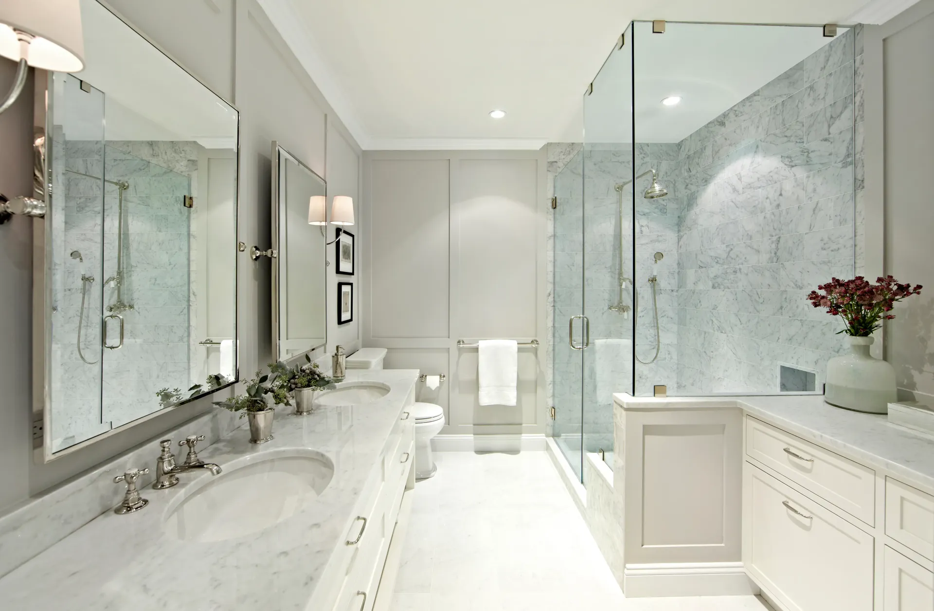 A bathroom with two sinks and a walk in shower