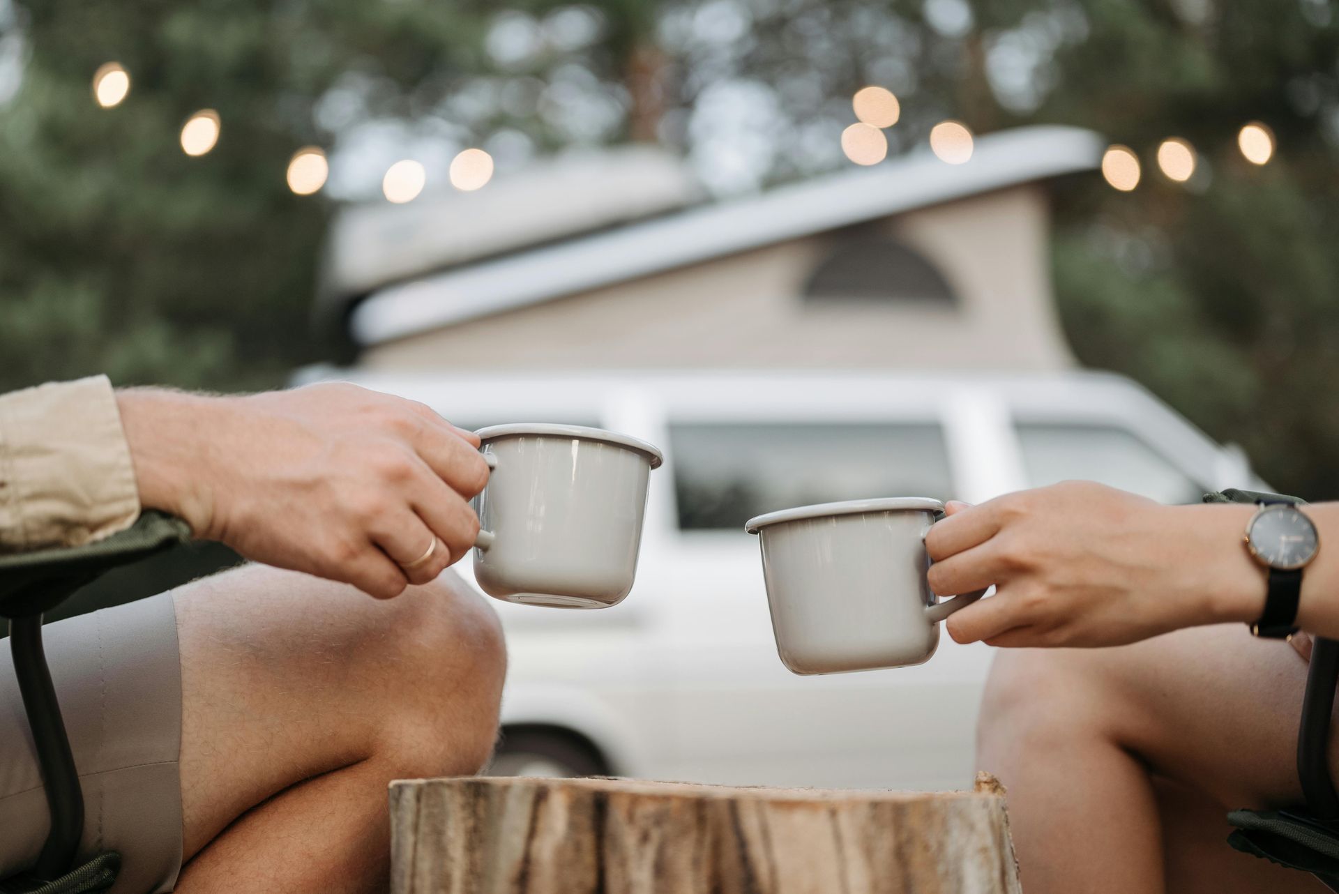 Ein Mann und eine Frau sitzen nebeneinander und halten Tassen Kaffee in der Hand.