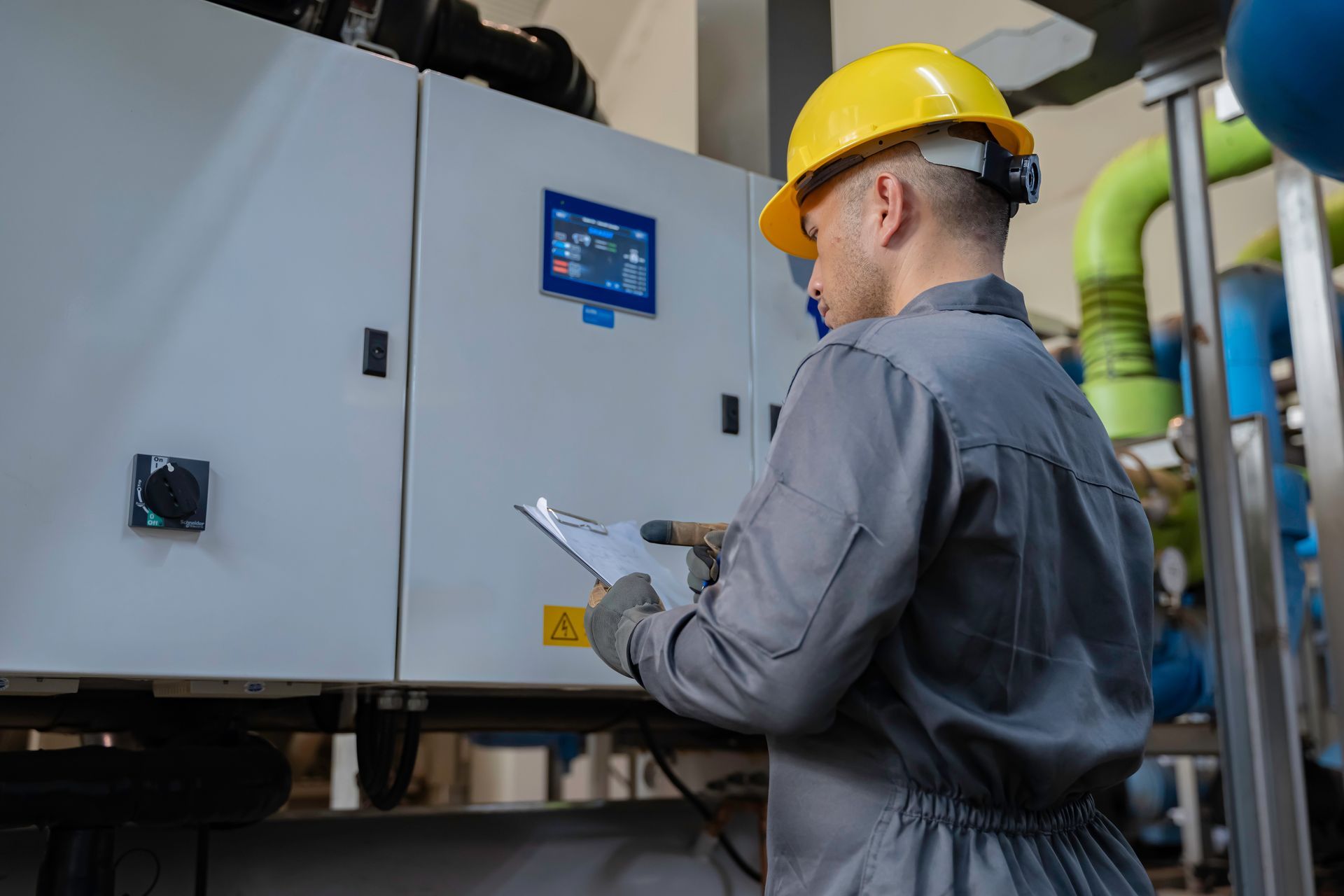 Professional technician inspecting electrical control panel. Professional technician inspecting electrical control panel.