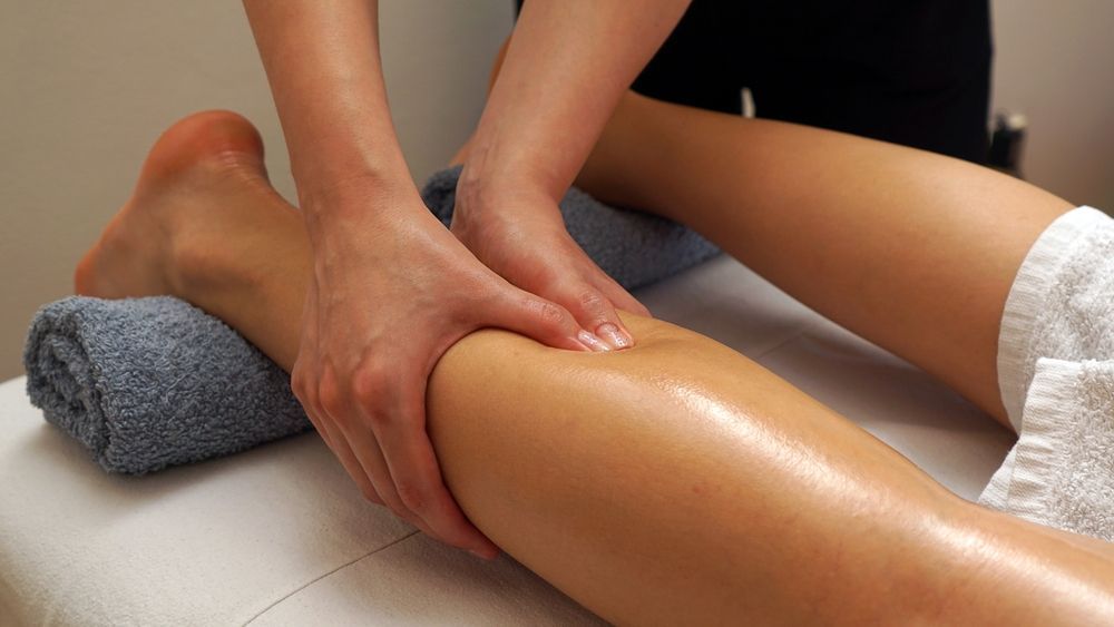 Hands Massaging a Leg on a Massage Table — A1 Coffs Harbour in Coffs Harbour, NSW