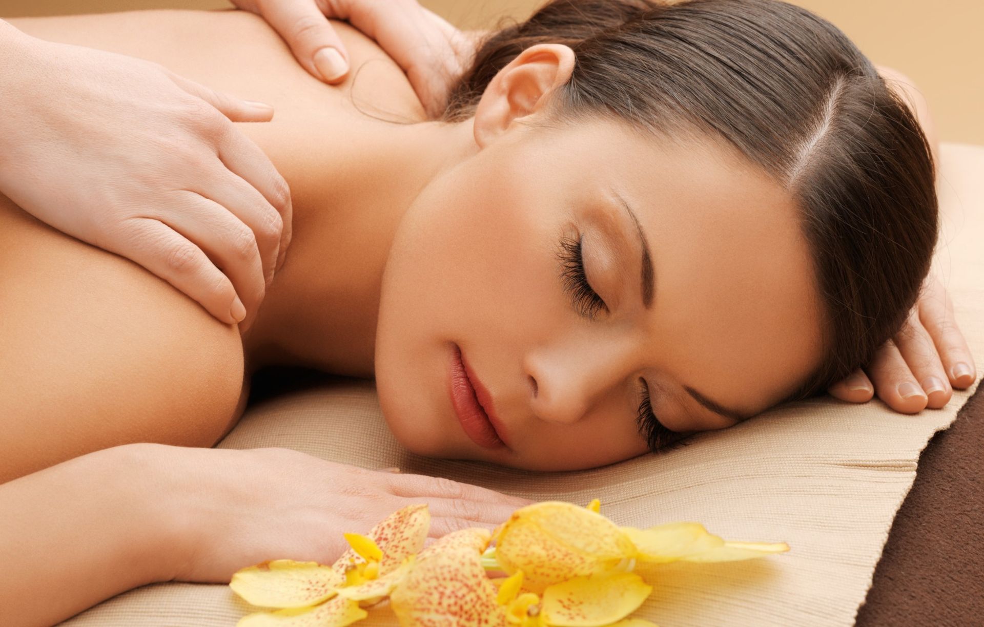 Woman receiving a back massage with eyes closed, yellow flower petals — A1 Coffs Harbour in Coffs Harbour, NSW