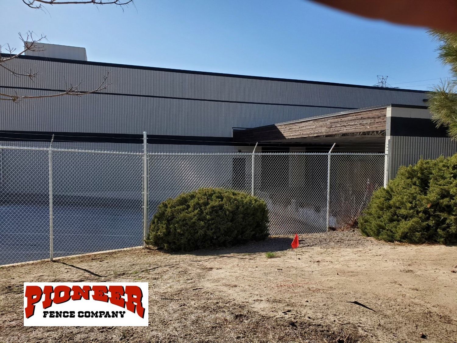 A chain link fence is in front of a large building