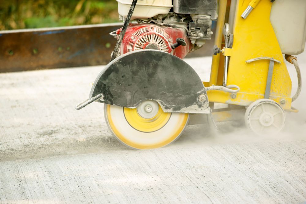 Yellow Concrete Saw Cutting Into a Concrete Surface — Ultra Services Ground Pavement & Building in Abercrombie, NSW