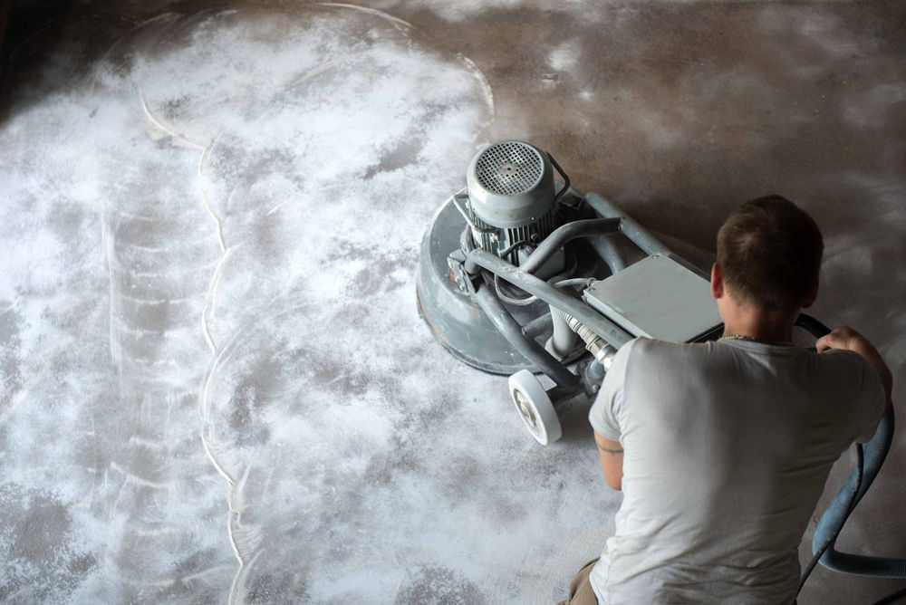 Person Grinding a Concrete Floor with A Industrial Machine — Ultra Services Ground Pavement & Building in Abercrombie, NSW