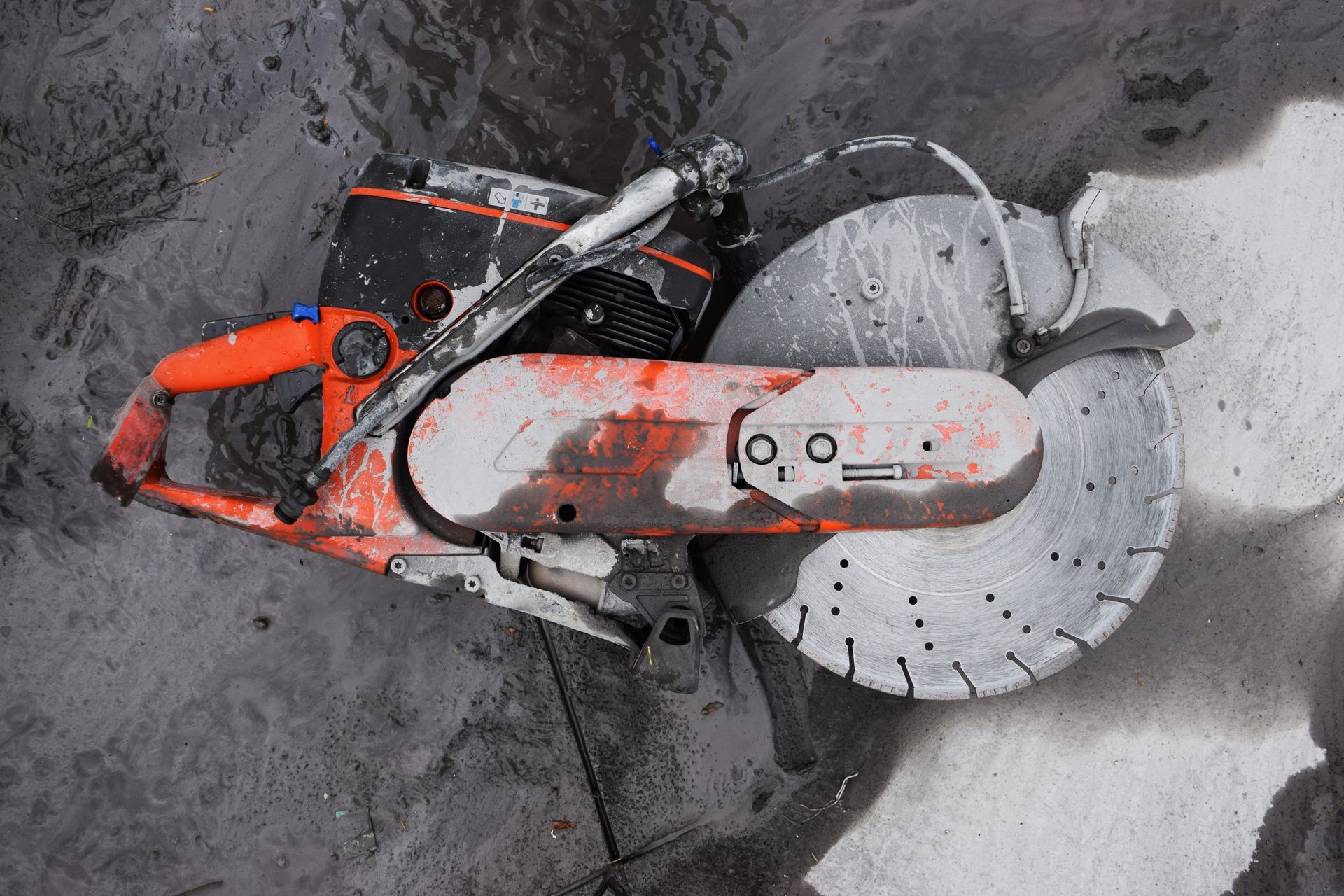 Orange and Black Concrete Saw Cutting Into Concrete Surface — Ultra Services Ground Pavement & Building in Mudgee, NSW