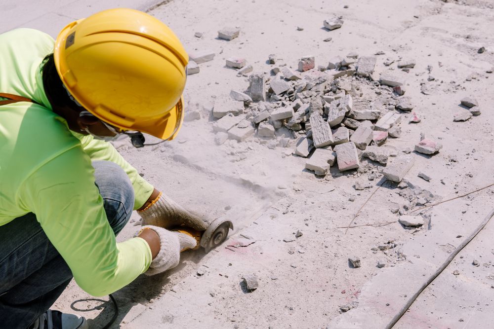 Construction Worker Cuts Concrete with A Power Saw — Ultra Services Ground Pavement & Building in Abercrombie, NSW
