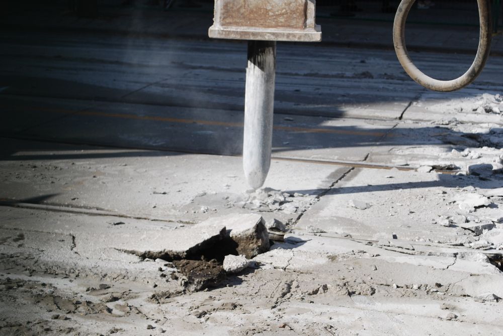Jackhammer Breaking up Concrete on A Road Surface — Ultra Services Ground Pavement & Building in Abercrombie, NSW