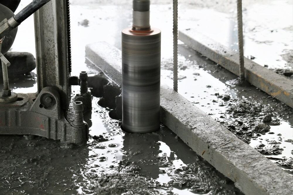 A Core Drill Cutting a Cylindrical Hole in Wet Concrete — Ultra Services Ground Pavement & Building in Abercrombie, NSW