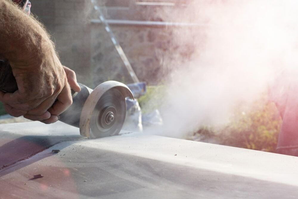 Person Using Power Saw to Cut a Stone Slab — Ultra Services Ground Pavement & Building in Abercrombie, NSW