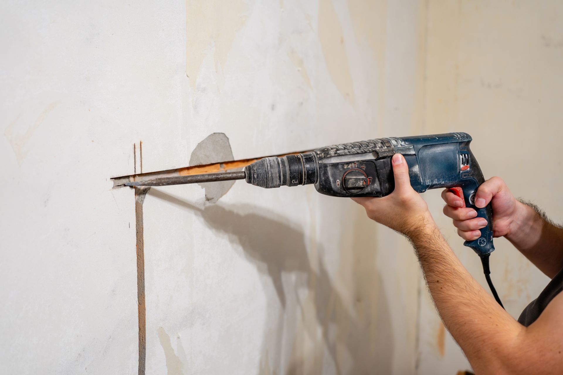 Person Using a Power Drill on A Wall to Create a Hole — Ultra Services Ground Pavement & Building in Cobar, NSW