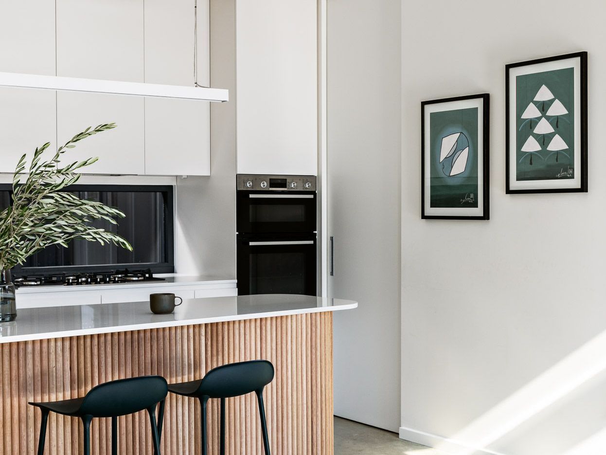 A Kitchen With Stools And A Clock On The Wall — Concept Design Kitchens & Joinery In Hawks Nest, NSW