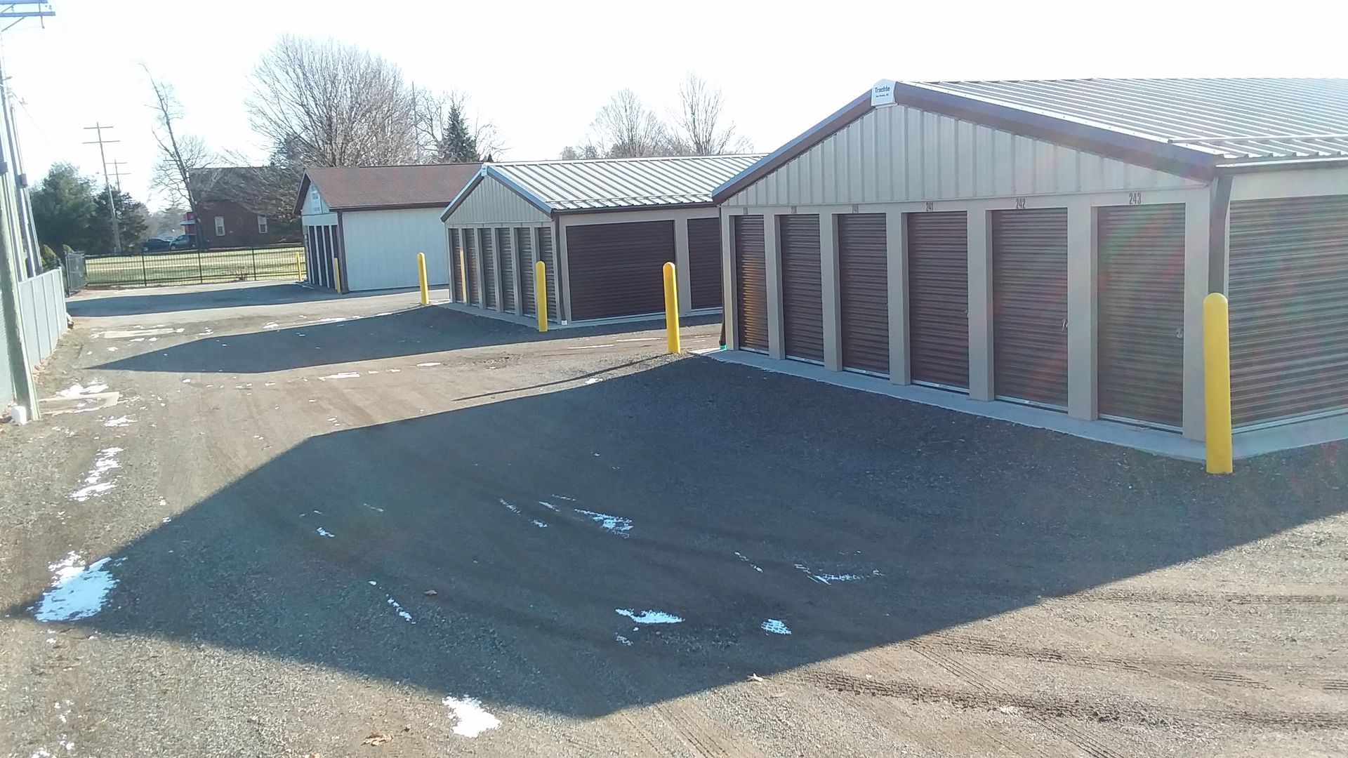 A row of storage units with yellow poles in front of them