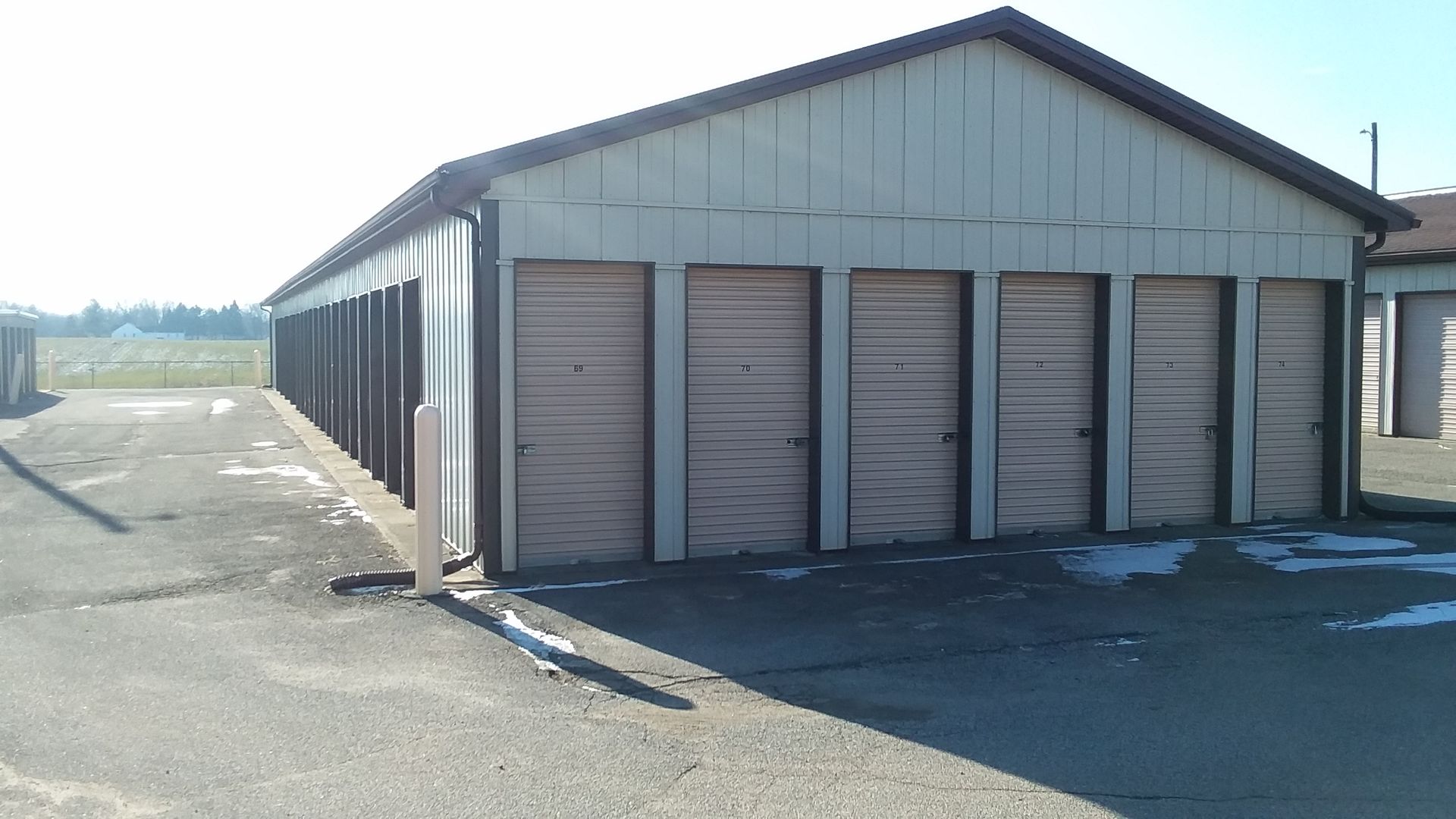 A row of storage units are lined up in a parking lot
