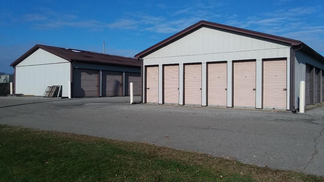 A row of storage units with wooden doors on a sunny day.