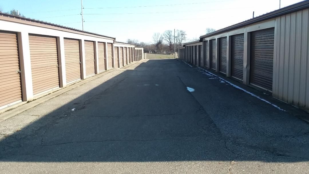 A row of storage units are lined up on the side of a road.