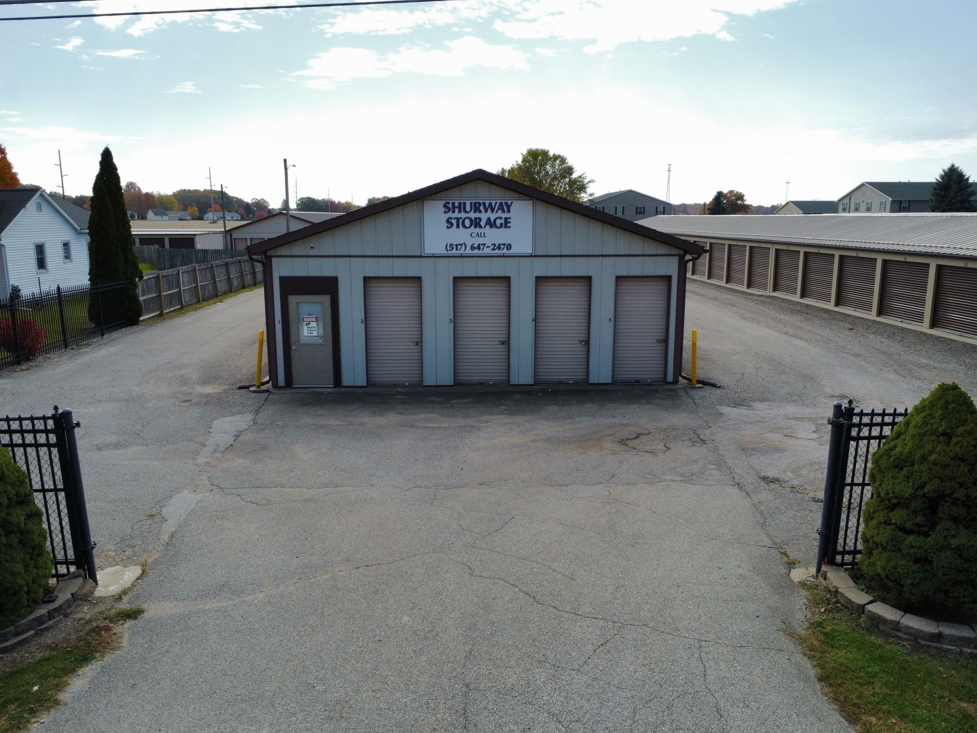 An aerial view of a storage facility with a fence in front of it.