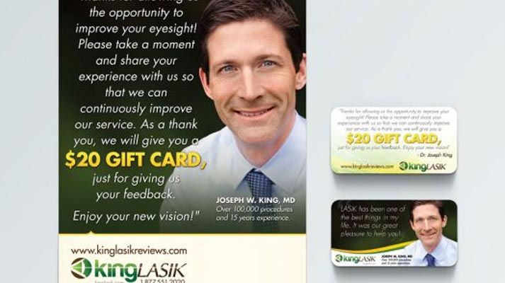 a man in a suit and tie is smiling and holding a $20 gift card .