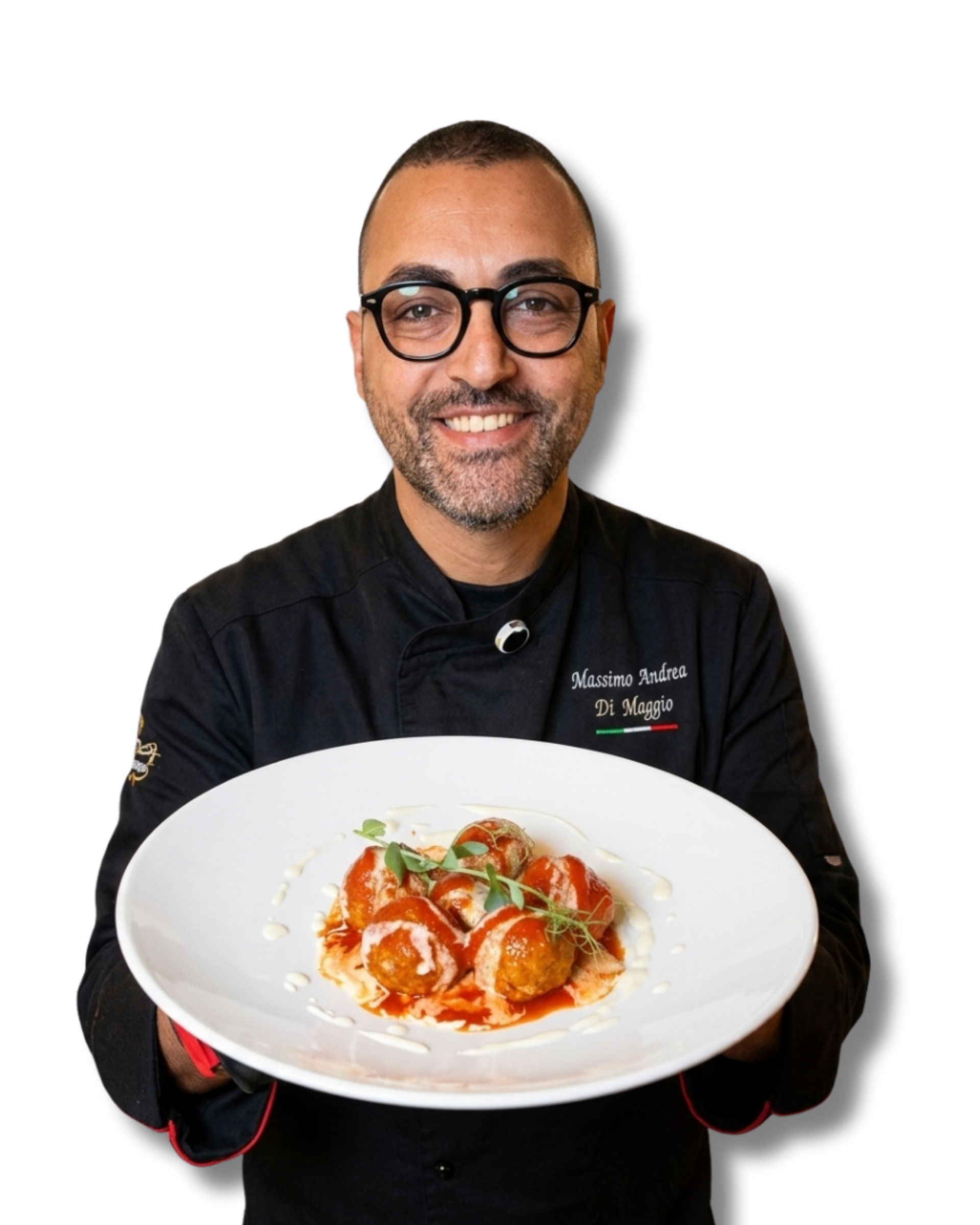 Uno chef sorridente, con in mano un piatto bianco di pasta e indosso una giacca da chef nera, si staglia su uno sfondo bianco.