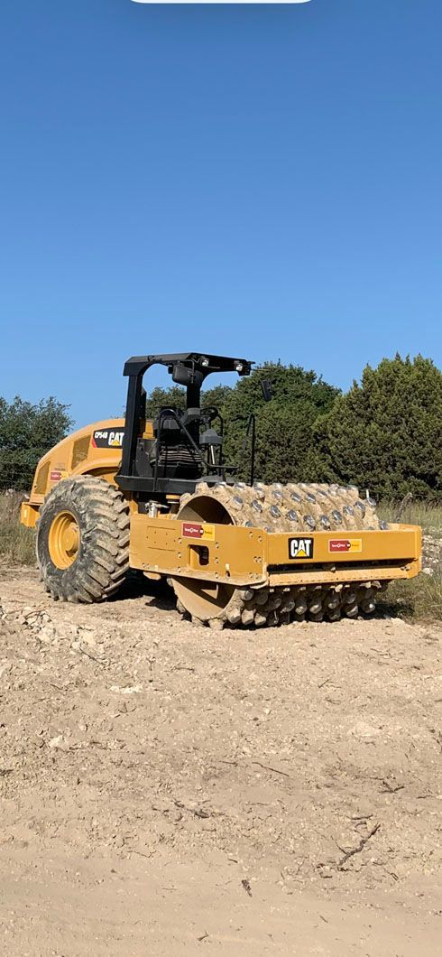 A yellow bulldozer is sitting on top of a dirt field.