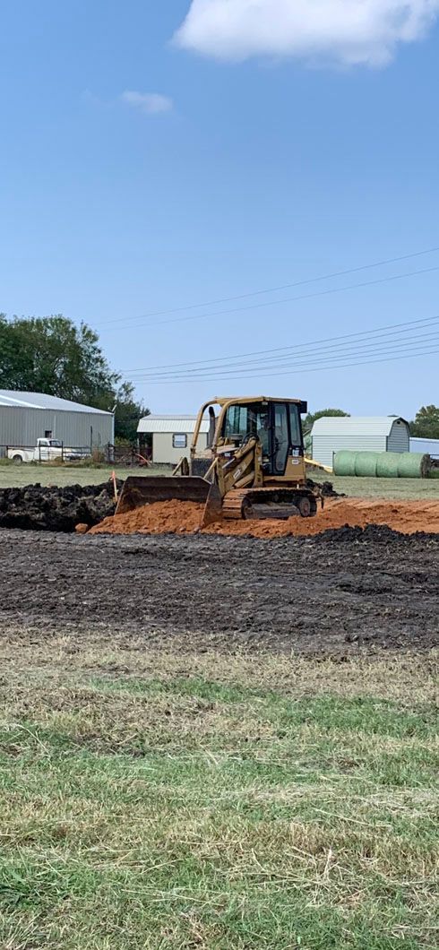 A bulldozer is moving dirt in a field.