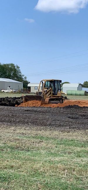 A bulldozer is moving dirt in a field.