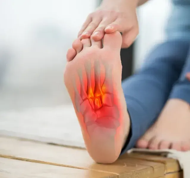 Foot with highlighted bones in red indicating pain; person holding foot.