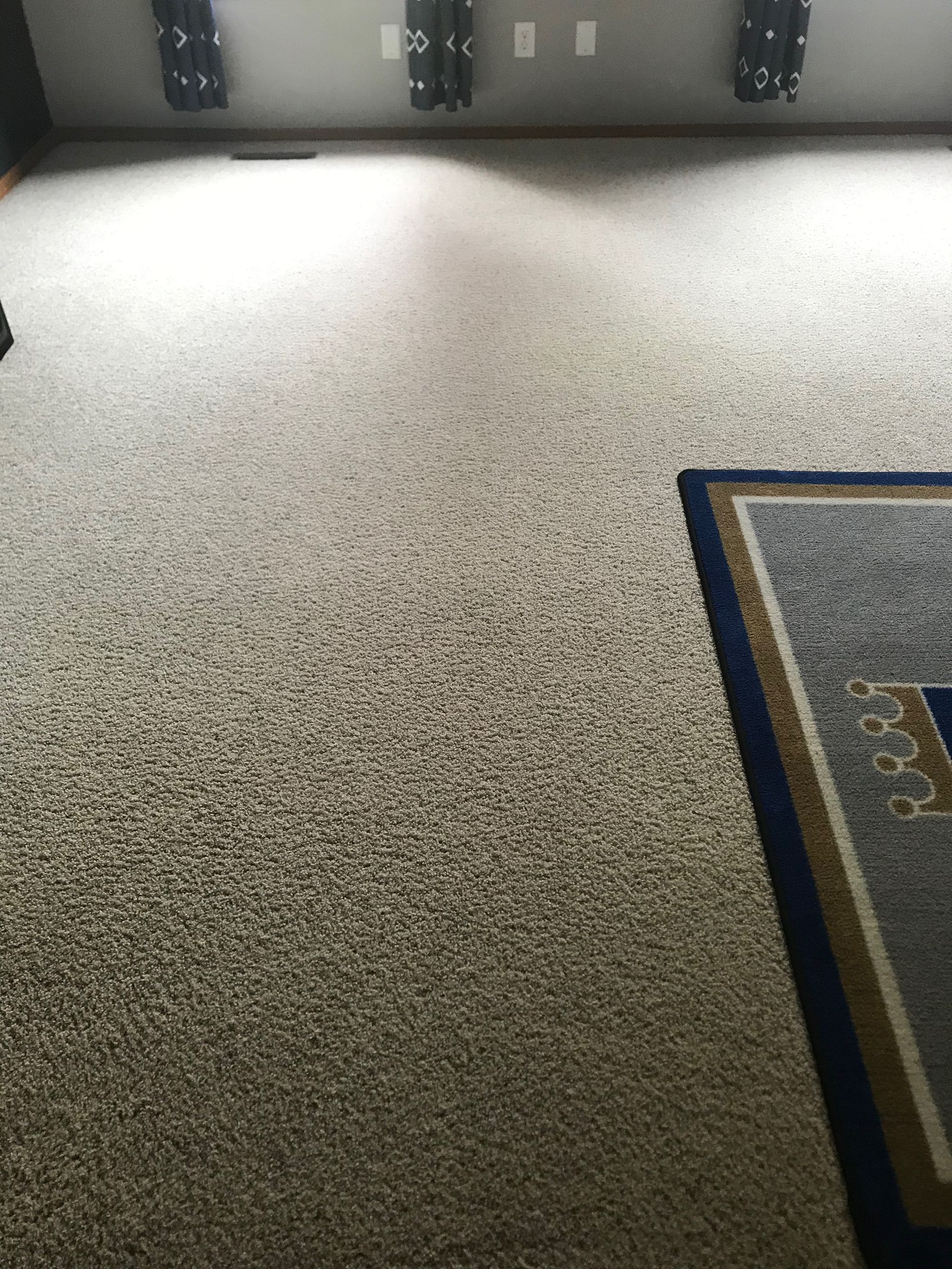 A room with a rug on the floor and a carpet on the floor.