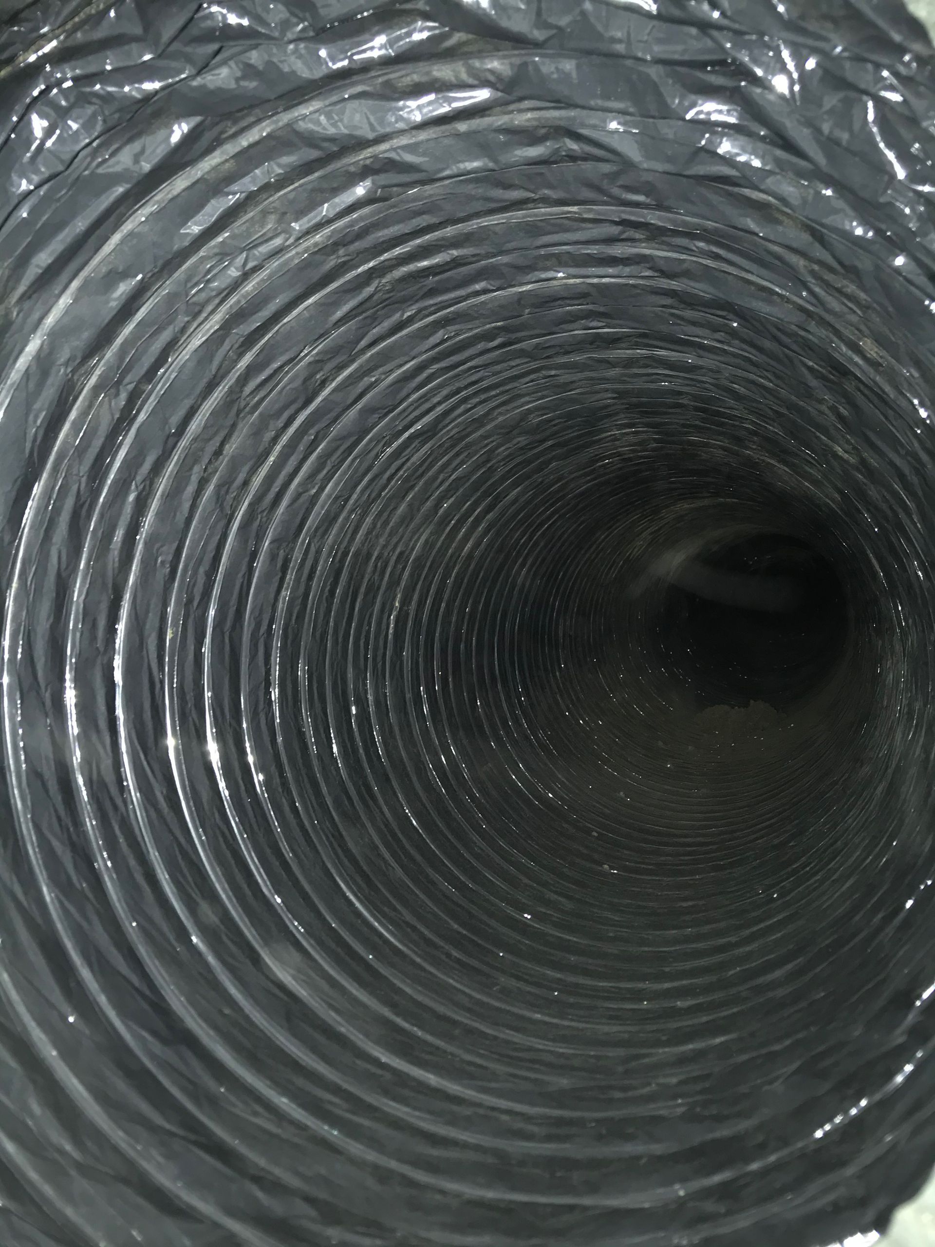 A close up of a black duct with a hole in the middle.