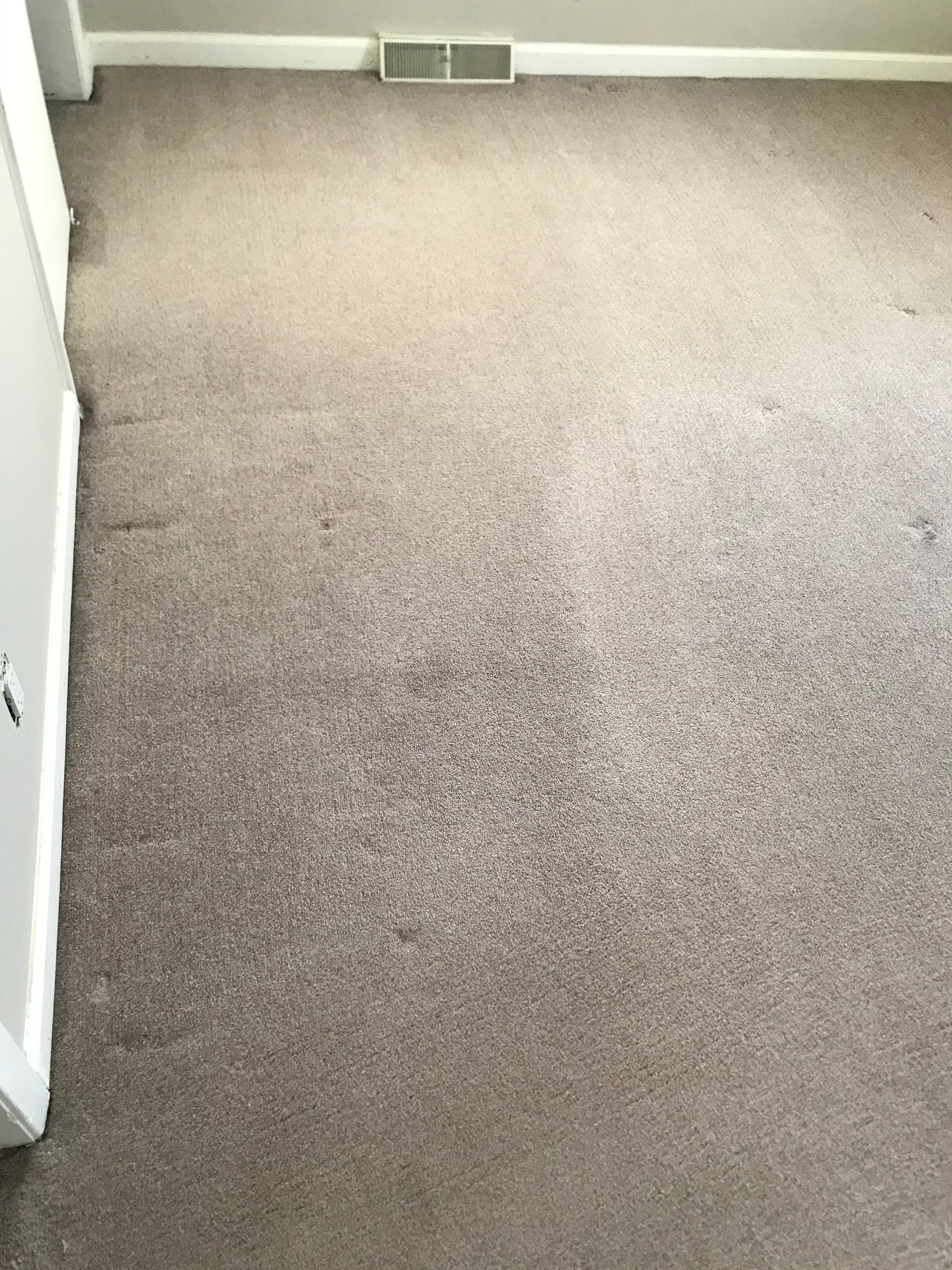 A room with a carpeted floor and a white wall.