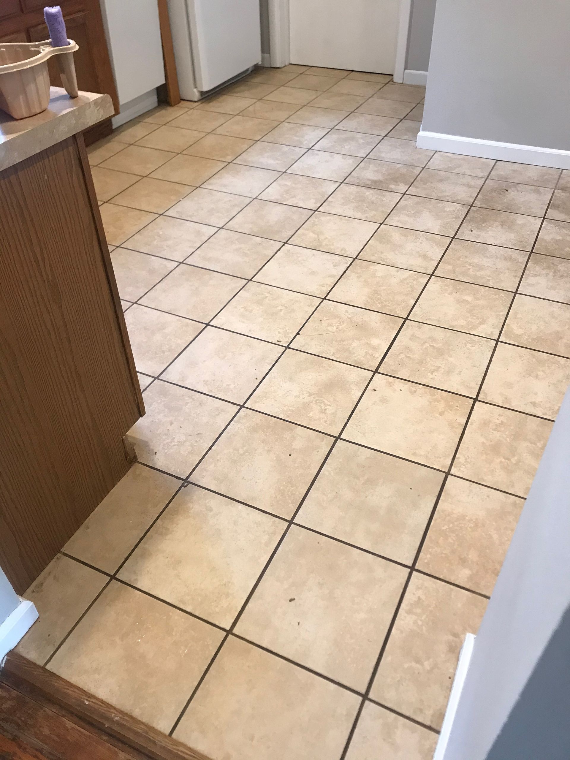 A kitchen with a tile floor and a wooden counter top.