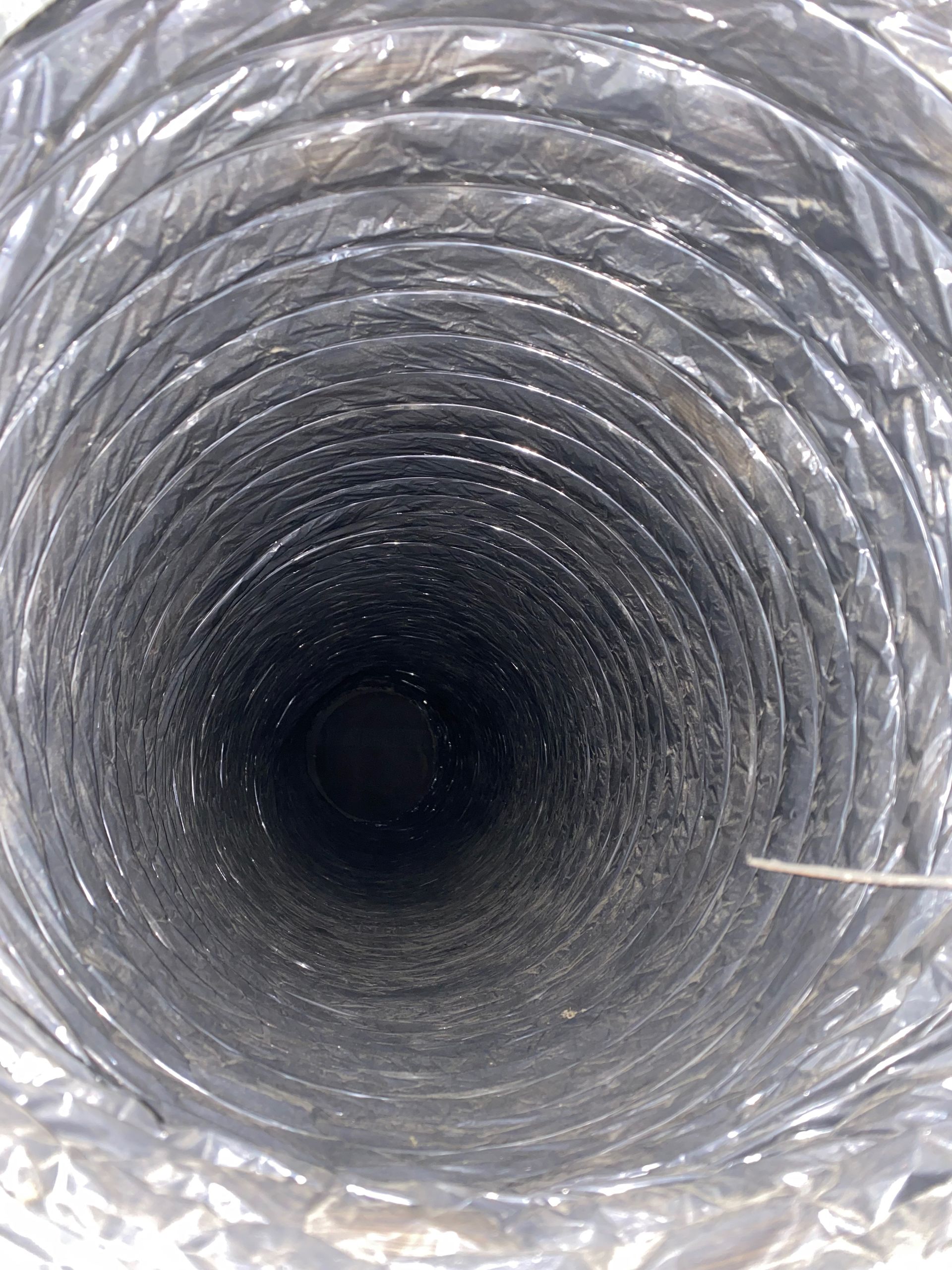 A close up of the inside of a duct with a needle sticking out of it.