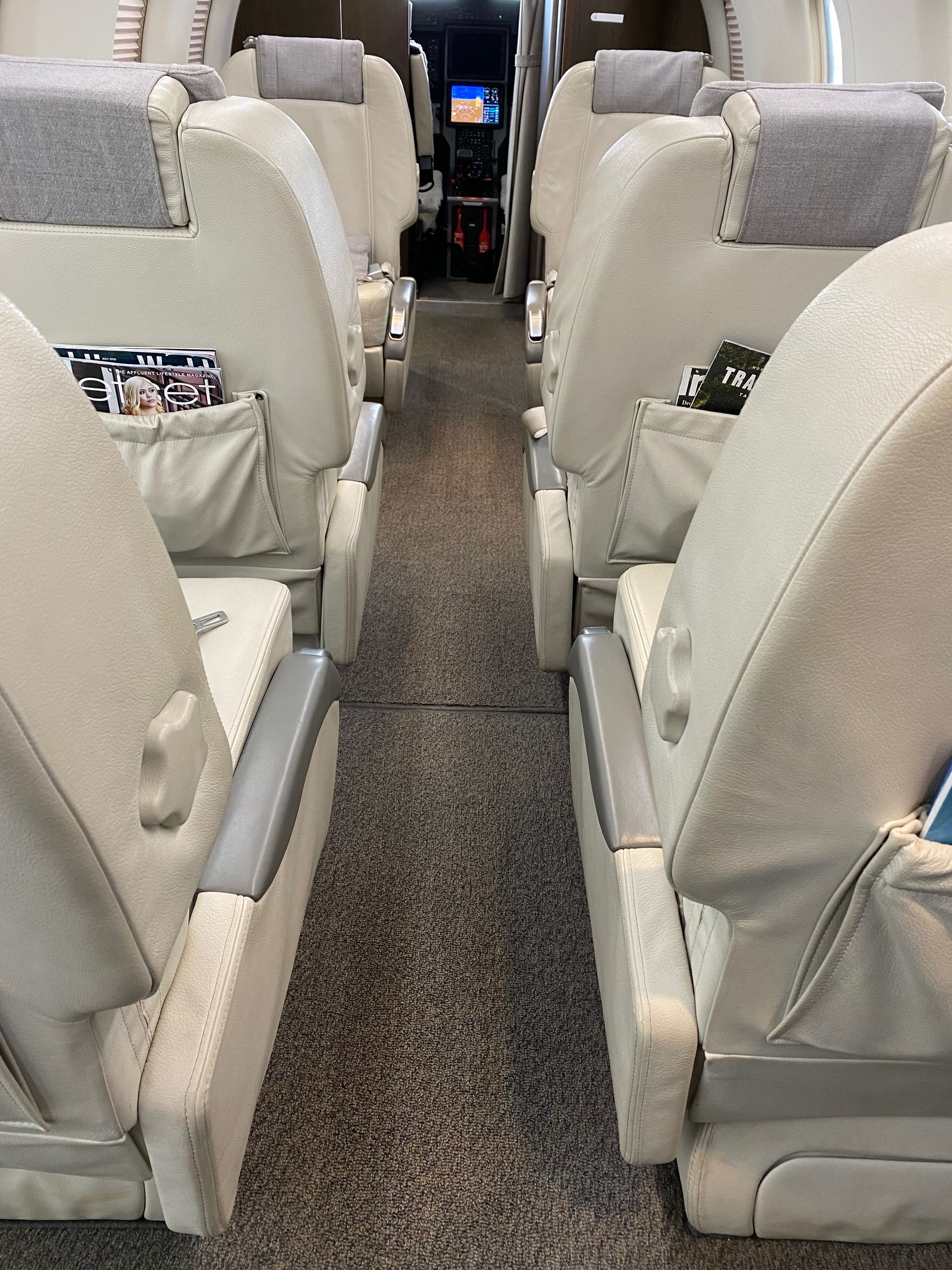 A row of white seats on an airplane with a gray headrest