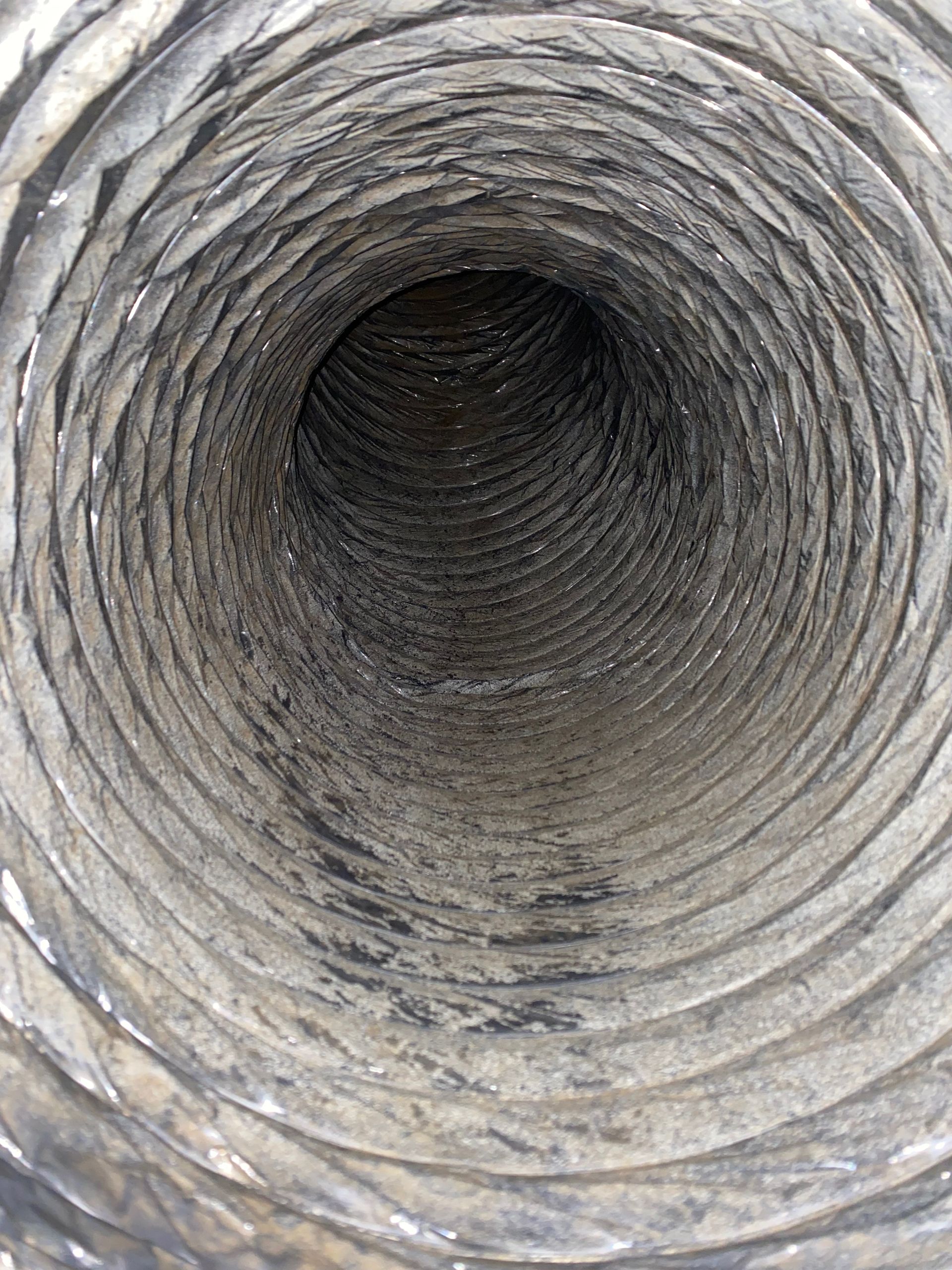 A close up of the inside of a dirty air duct.