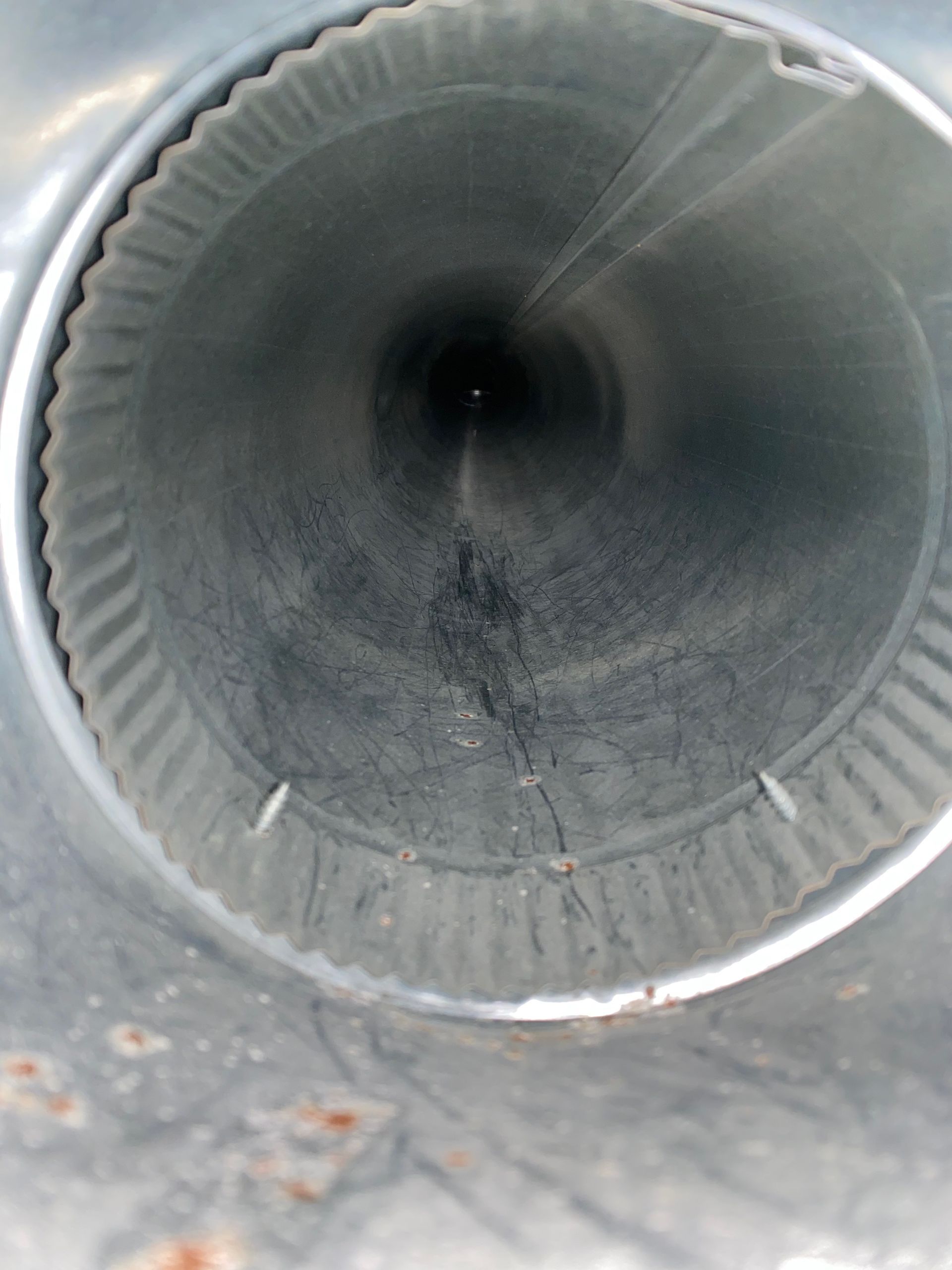 The inside of a metal pipe with a hole in the middle