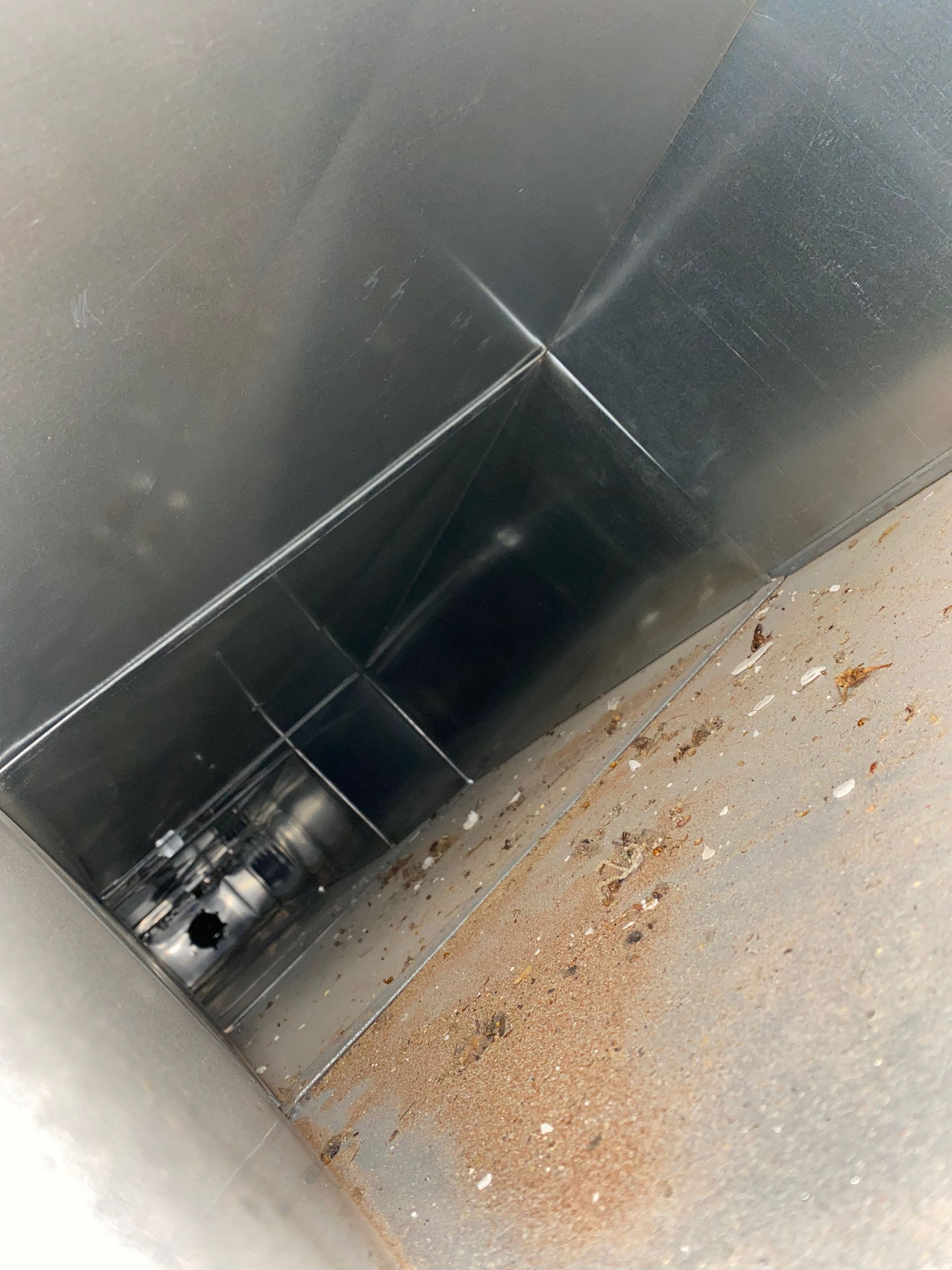 A close up of a dirty duct in a room.