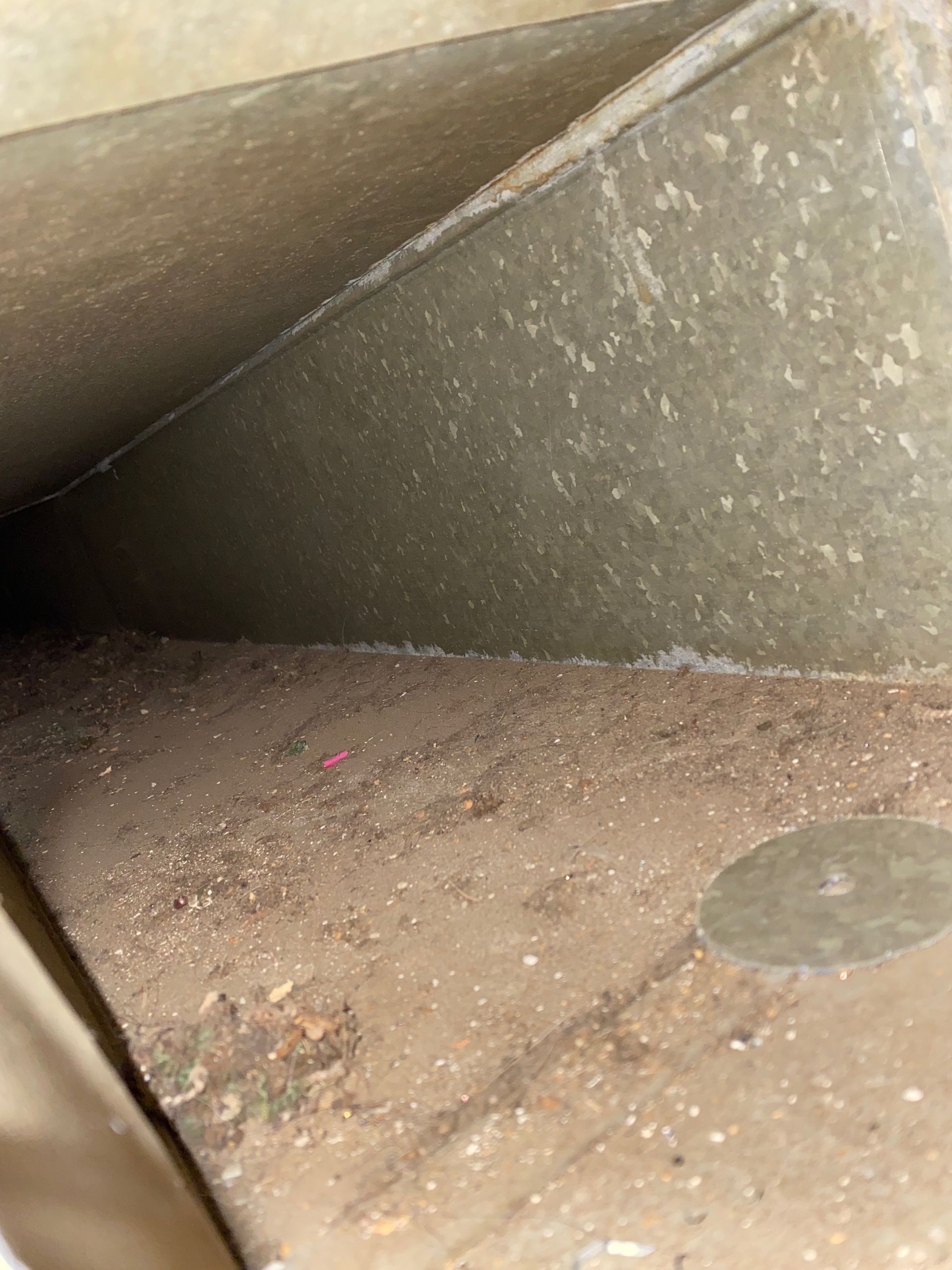 A close up of a dirty concrete wall with a hole in the middle.
